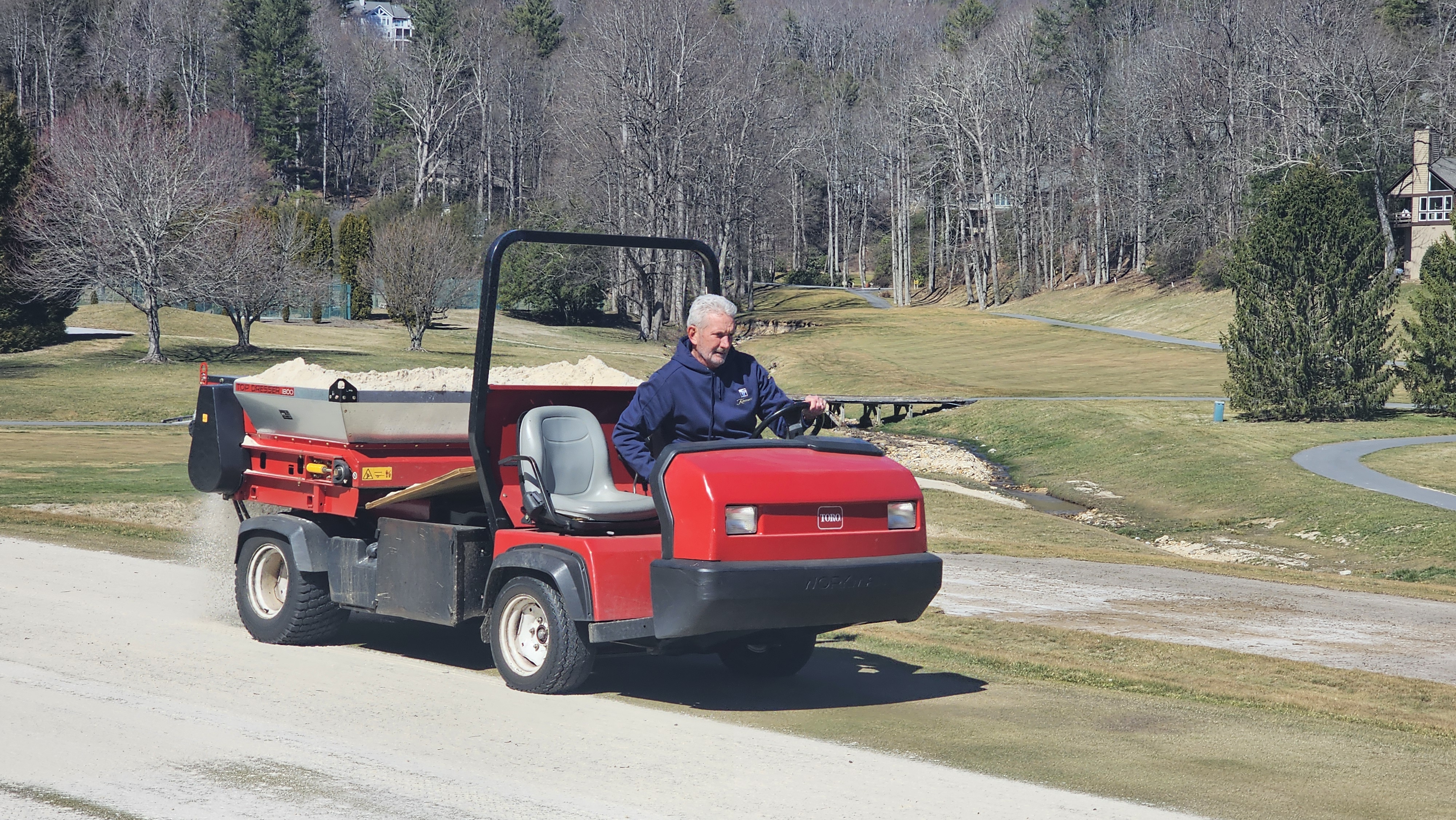 Brad driving a Toro topdresser loaded with sand